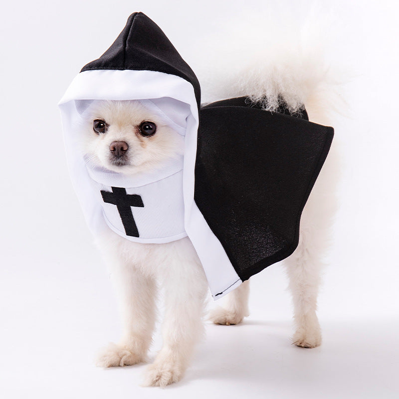 White fluffy dog wearing a black cape nun costume with white hood trim and a black cross front panel