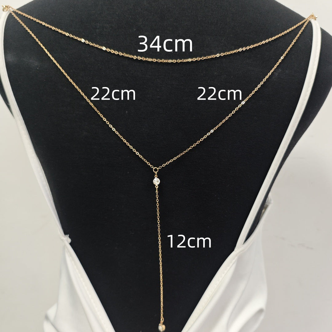 Layered rhinestone back necklace draped over a black jewelry display stand
