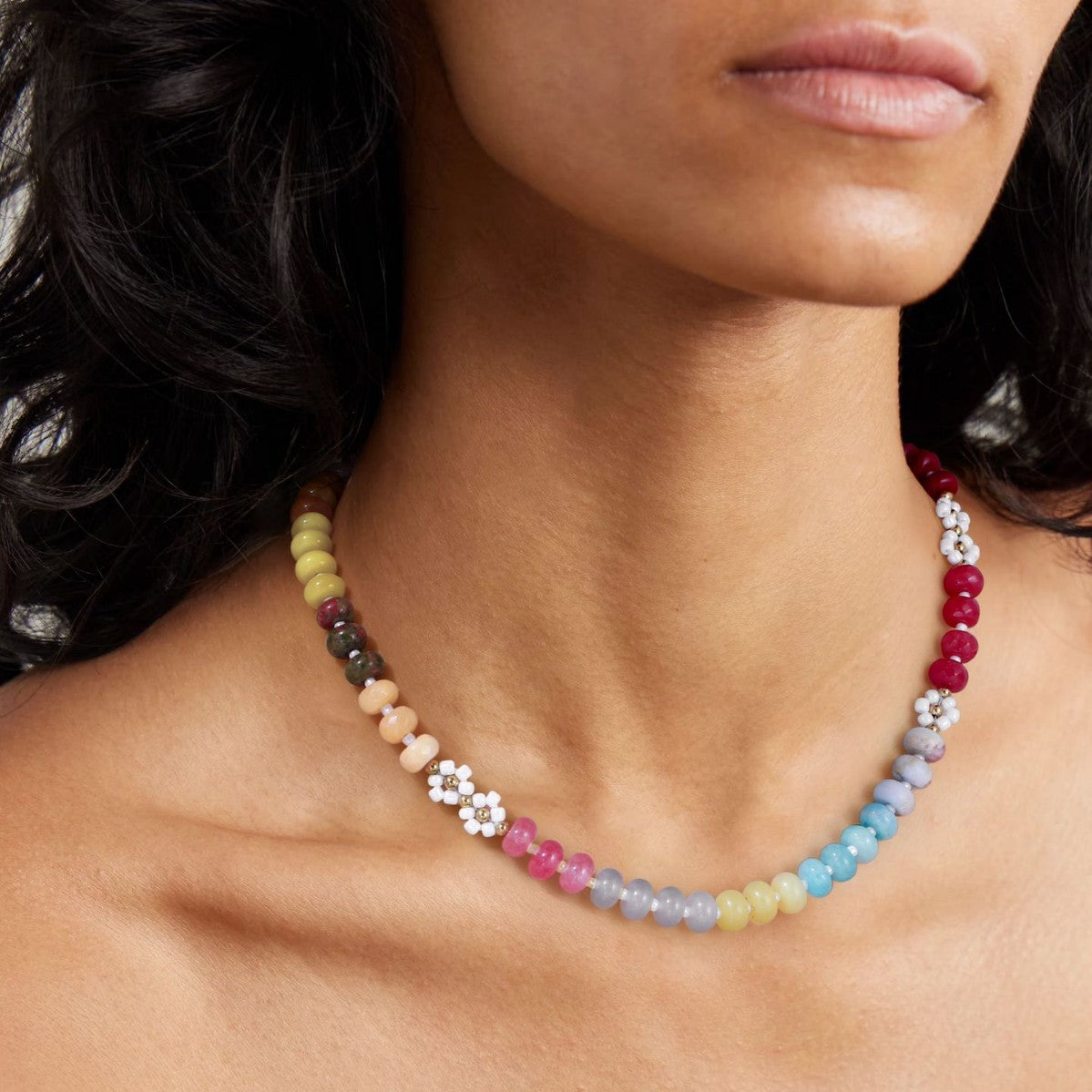 Natural stone and pearl beaded necklace laid flat showing gold tone spacer beads and daisy flowers