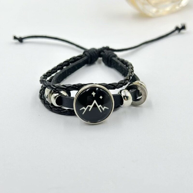 Pink braided cord bracelet with a moon charm shown adjustable with a sliding knot