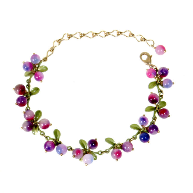Red and yellow bead clusters with green leaves on a gold tone charm bracelet