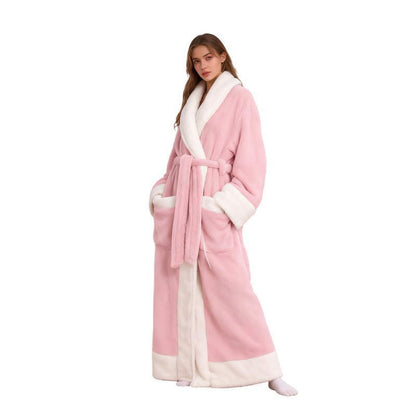 Woman wearing a long pink plush flannel bathrobe with a white shawl collar, tie belt and white cuffs and hem