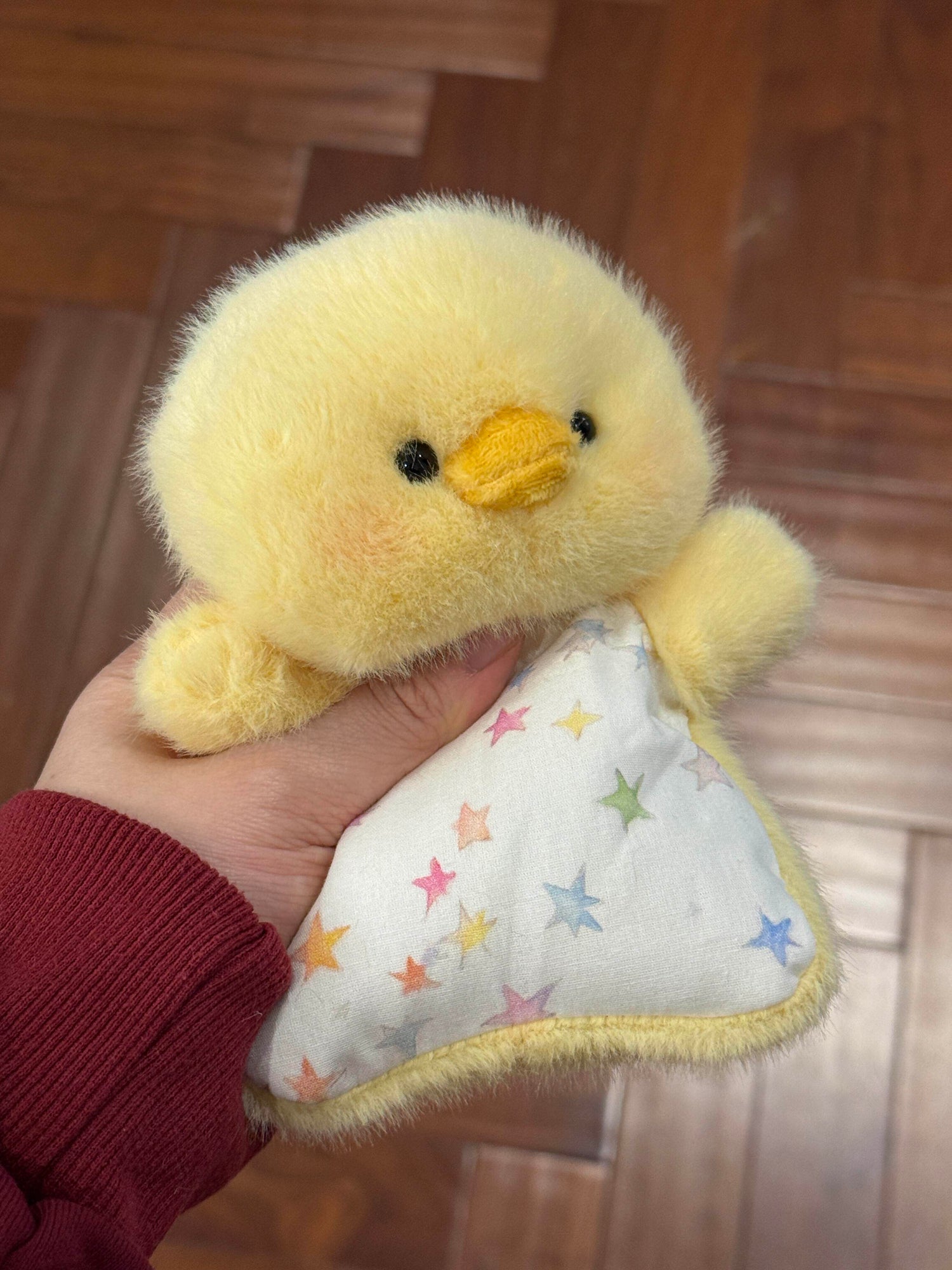 Palm sized squishy bean bag plush animal toy with brushed faux fur and a printed cotton apron