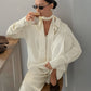 Buttercream loose shirt worn open over the wide leg trousers set, standing with a coffee in hand