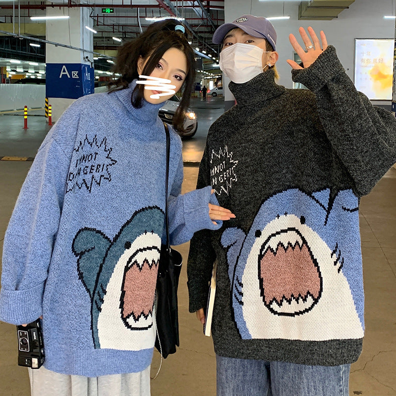 Couple wearing matching blue and charcoal cartoon shark turtleneck sweaters in a parking garage