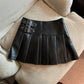Black with Buckle Straps variant, size XL: black pleated mini skirt with two buckle straps on a cream sofa