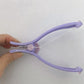 Close view of the lilac threading tool with its central dial and cotton thread across the arc