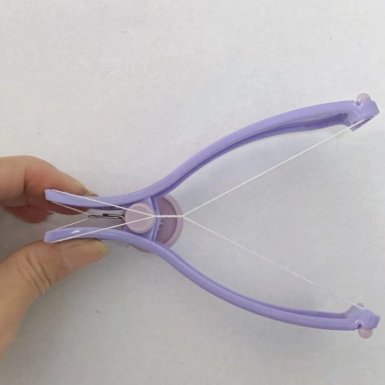 Close view of the lilac threading tool with its central dial and cotton thread across the arc