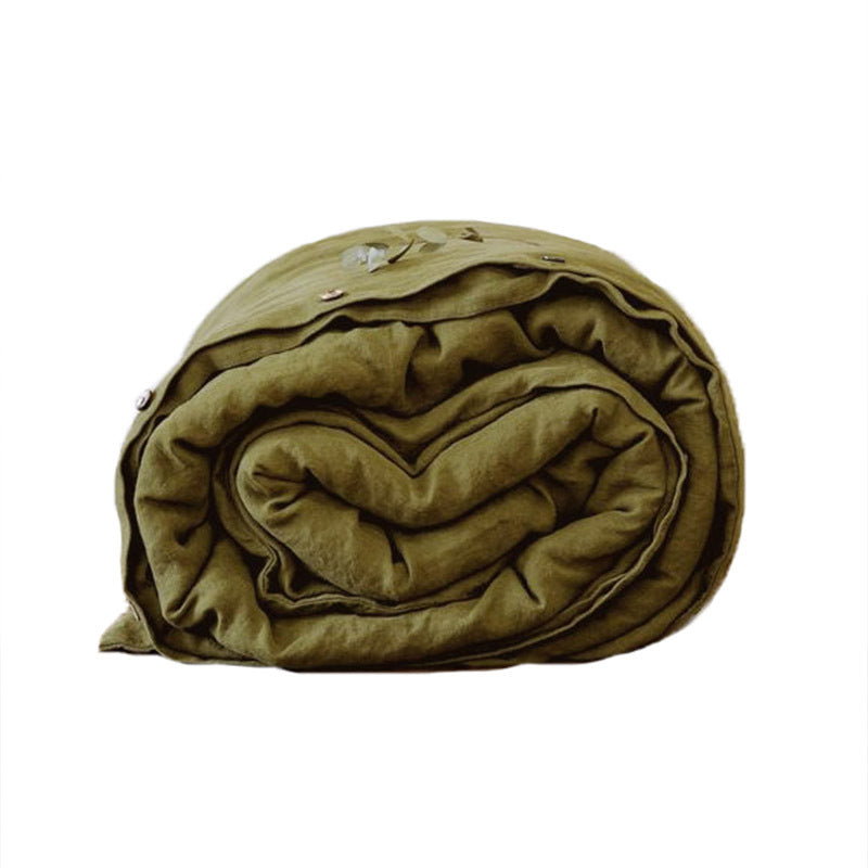 Washed pure linen duvet cover folded and rolled on a wooden surface