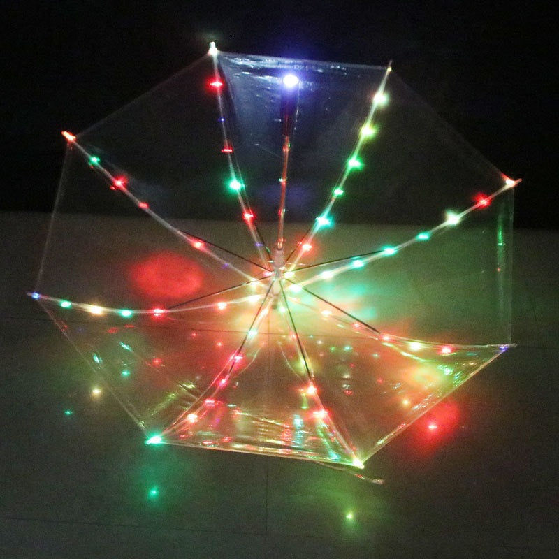 Top view of an open clear LED umbrella at night with multicolor lights on each rib