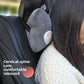 Woman resting her head against a gray cartoon headrest pillow fitted on a car seat headrest