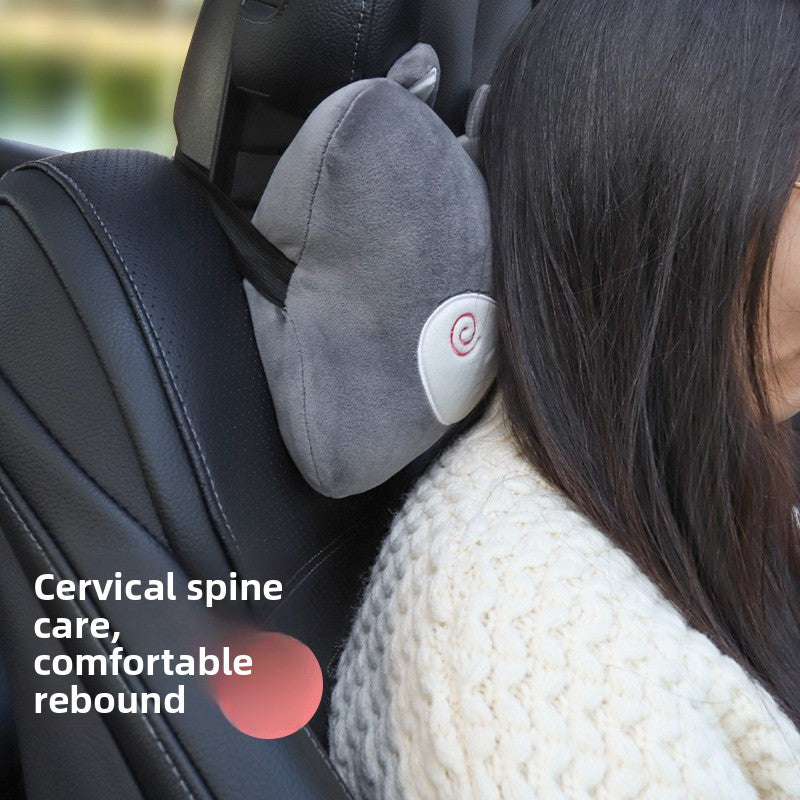 Woman resting her head against a gray cartoon headrest pillow fitted on a car seat headrest