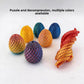 Several 3D printed dragon egg fidget toys in metallic colors on a white background
