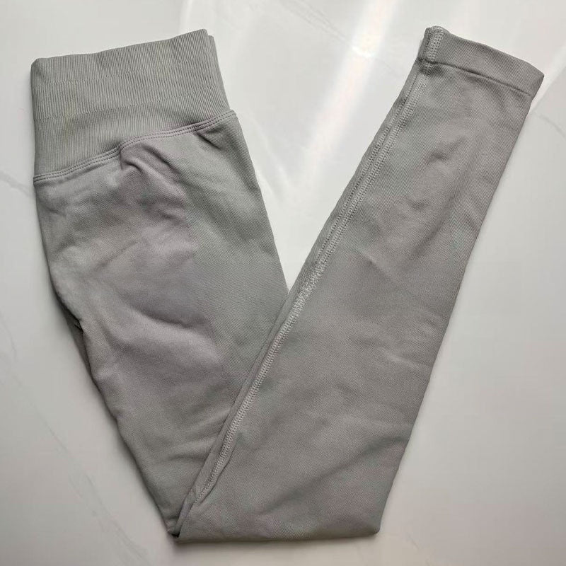 Light grey seamless leggings with the curved knitted seat panel visible on the flat lay