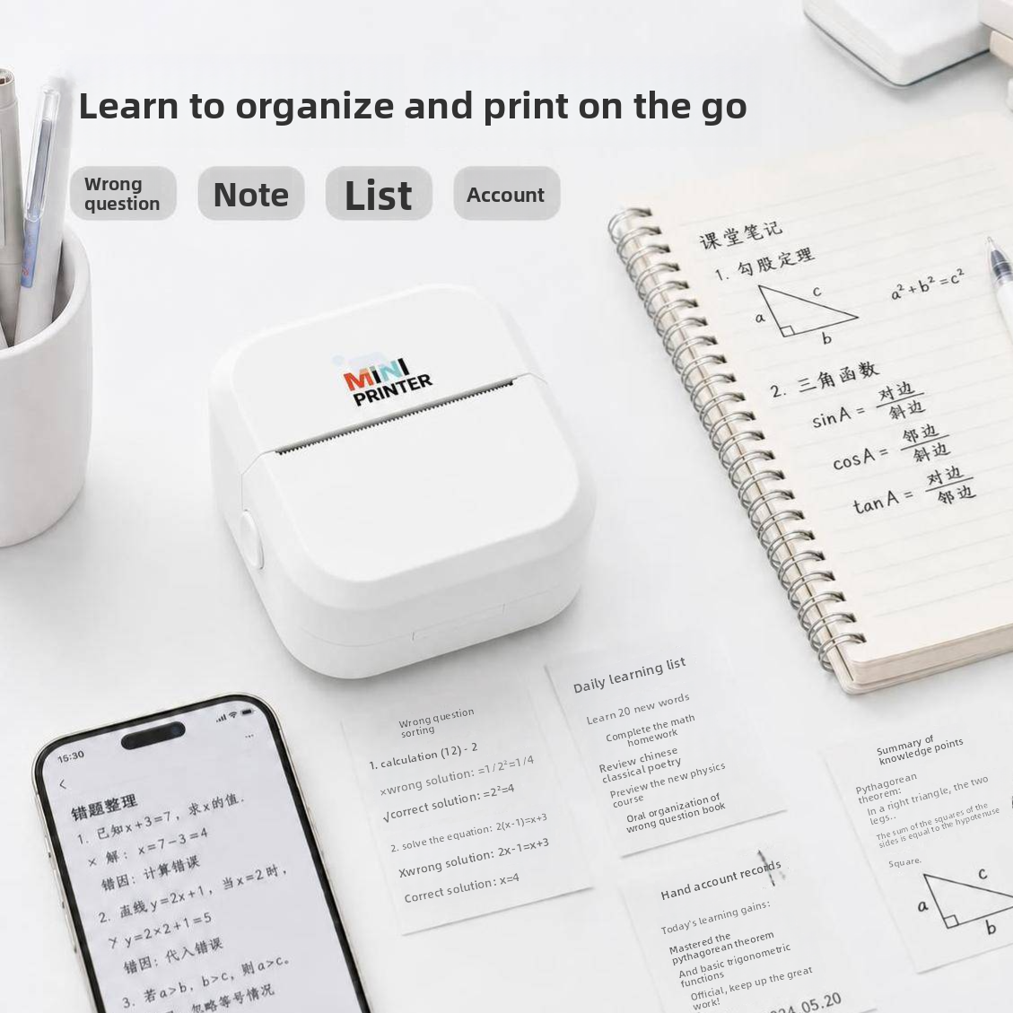 White mini thermal printer on a desk with printed study notes, a phone and a notebook