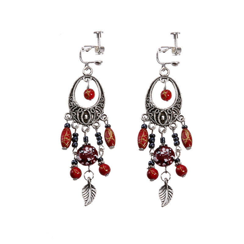 Handmade bohemian clip-on earrings with tassel and bead drop detail, zinc alloy frame, studio shot on white background