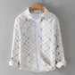 White ground shirt jacket with a grid of frayed multicolor patches on a hanger