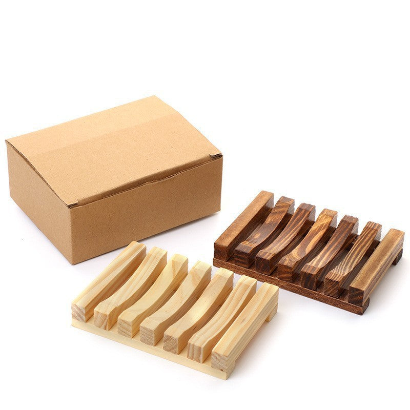 Natural and brown pine soap racks beside a closed kraft cardboard box