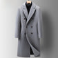 Grey double-breasted long coat with peak lapels on a hanger over a black turtleneck, front view