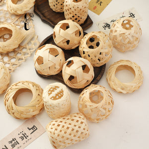 Handwoven bamboo woven balls and rings grouped on a dark wood tray and white table