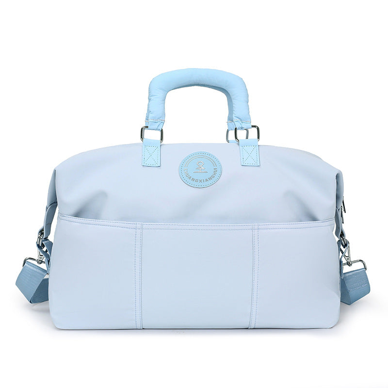 Light blue duffel travel bag with padded top handles, front slip pockets and shoulder strap, second view