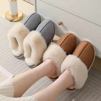 Gray and brown plush cuff slip-on mule slippers on a striped rug beside a pair of feet
