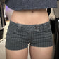 Front view of the pinstripe denim shorts worn low on the hips with a cropped knit
