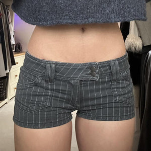 Front view of the pinstripe denim shorts worn low on the hips with a cropped knit