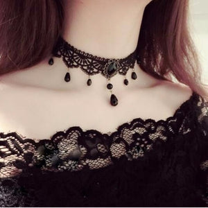 Black lace choker necklace with a faceted cabochon centre and bead drops worn at the neck