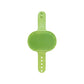 Full view of the green rubber groomer with its oval bristle head and adjustable strap of holes and snap studs