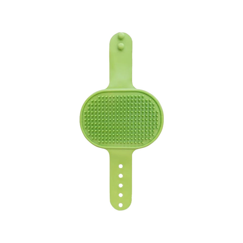 Full view of the green rubber groomer with its oval bristle head and adjustable strap of holes and snap studs