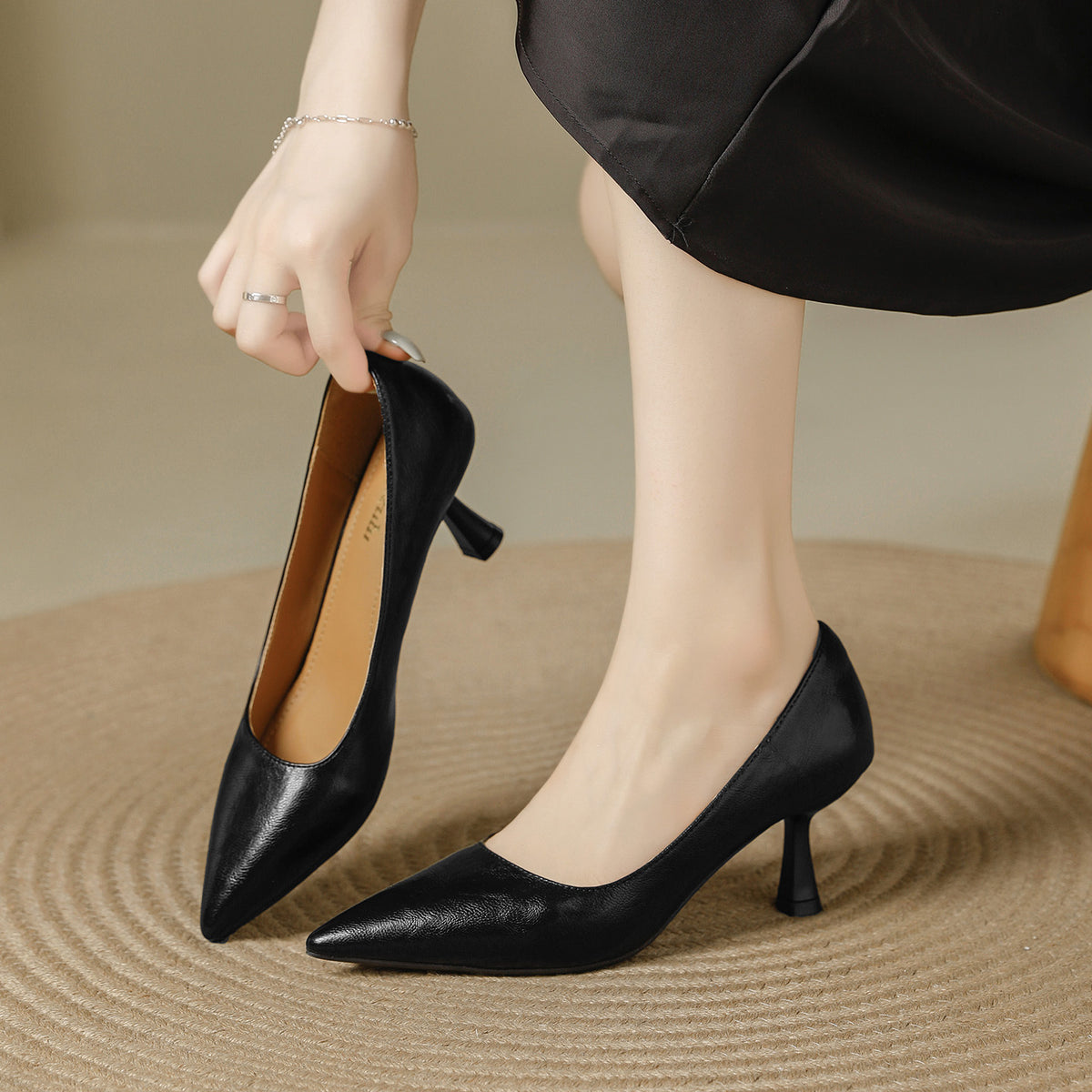 Black pointed toe pumps with a 6 cm slim heel, one held in hand, Black 6cm option, size 38