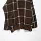 Close-up of the brown plaid knit side panel and sleeve edge of the cardigan on a white background