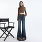 Front view of indigo flared denim trousers showing button and zip fly