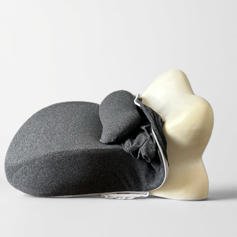 Deep gray back cushion supporting a pale mannequin torso, cover pushed up at the neck