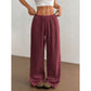 Woman wearing loose wide leg cotton trousers with a soft crinkle texture and tied waist