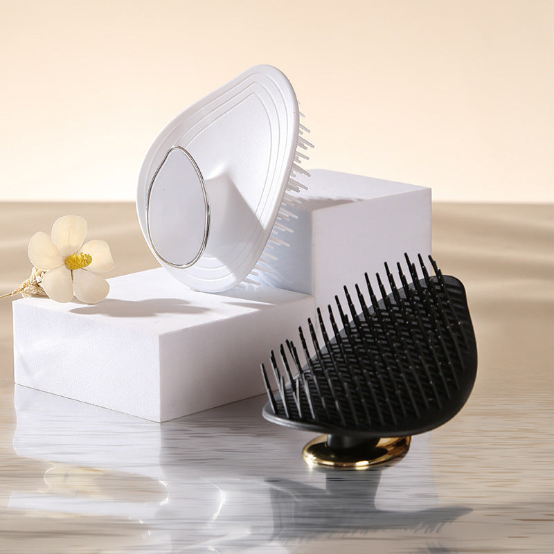 White leaf silicone scalp brush and a black one shown together on a counter