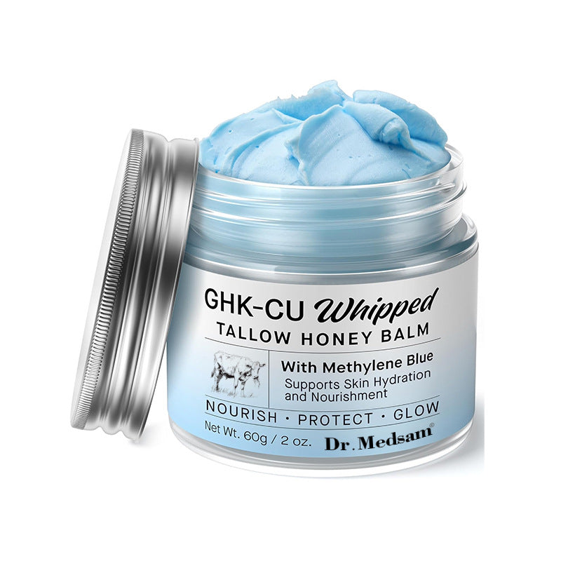 Open jar of blue whipped tallow and honey face balm with the silver lid beside it