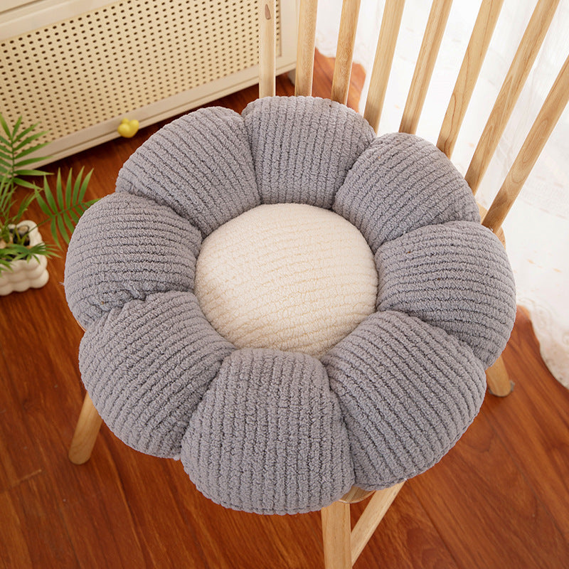 Flower shaped plush seat cushion on a chair in a cozy reading corner
