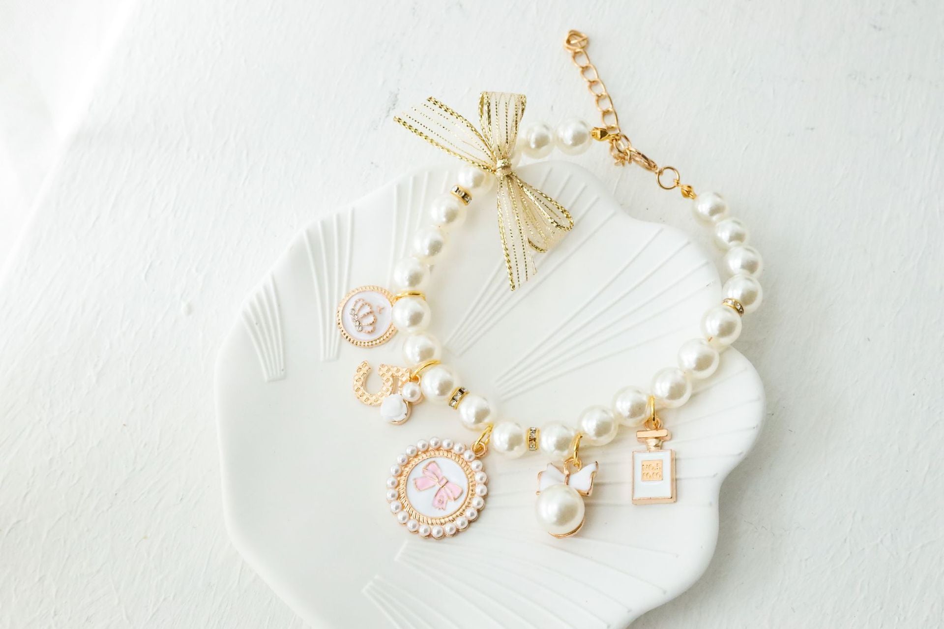 Adjustable faux pearl cat collar showing the gold lobster clasp and extender chain closure