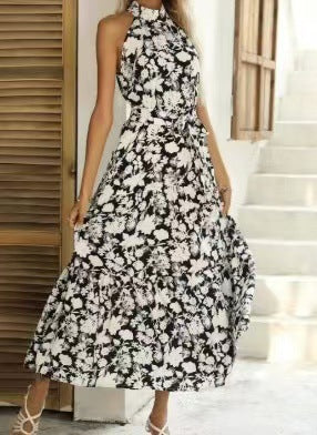 Black and white floral halter neck sleeveless tiered swing maxi dress worn by a model