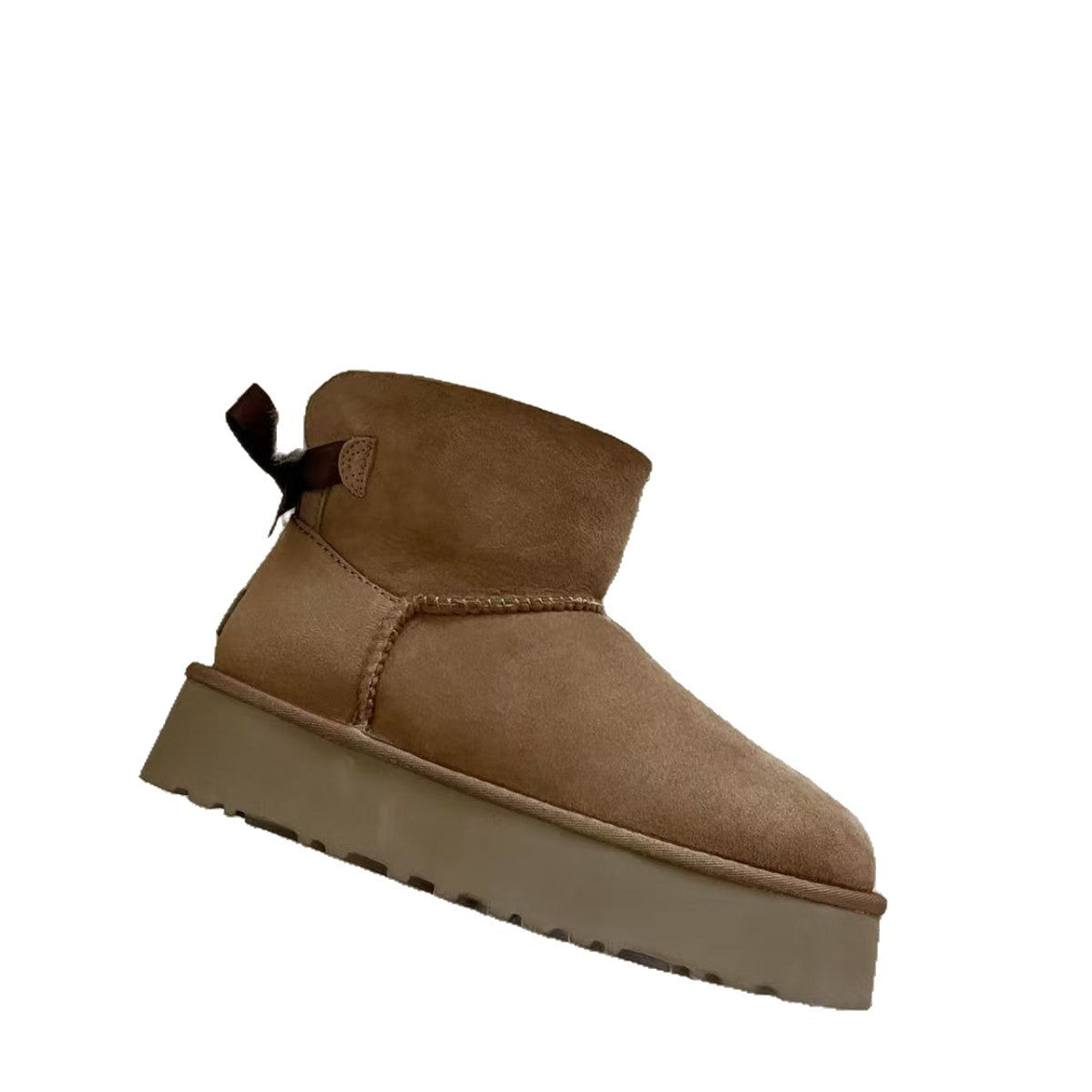 Chestnut suede platform ankle boot with a dark ribbon bow at the back on a white background, side view