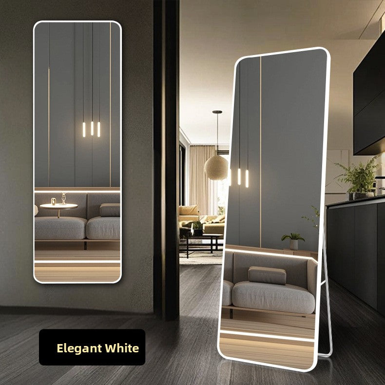 White framed wall mirror hung portrait in a modern living room beside a sofa