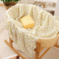 Folded cotton muslin swaddle blanket with a soft open weave and an even printed pattern