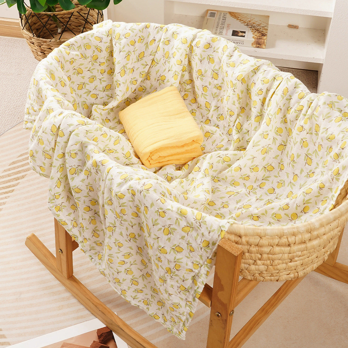 Folded cotton muslin swaddle blanket with a soft open weave and an even printed pattern