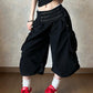 Black cotton wide leg cropped cargo pants with a double row buttoned waistband on a model