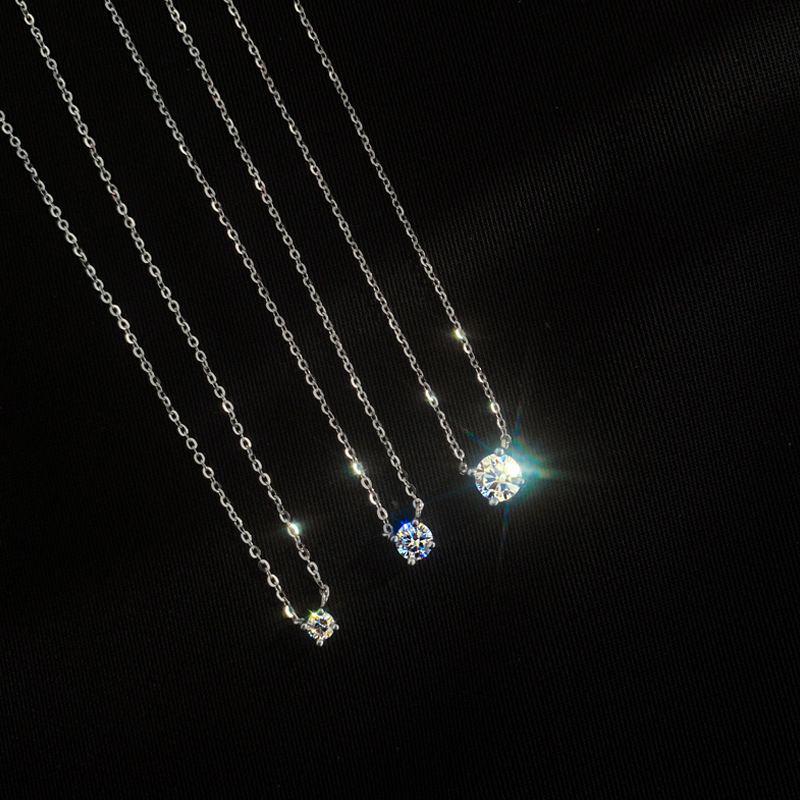 Single stone pendant necklace worn solo above an open neckline in daily wear