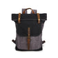 Gray and black canvas roll-top backpack front view with brown straps and buckled front flap