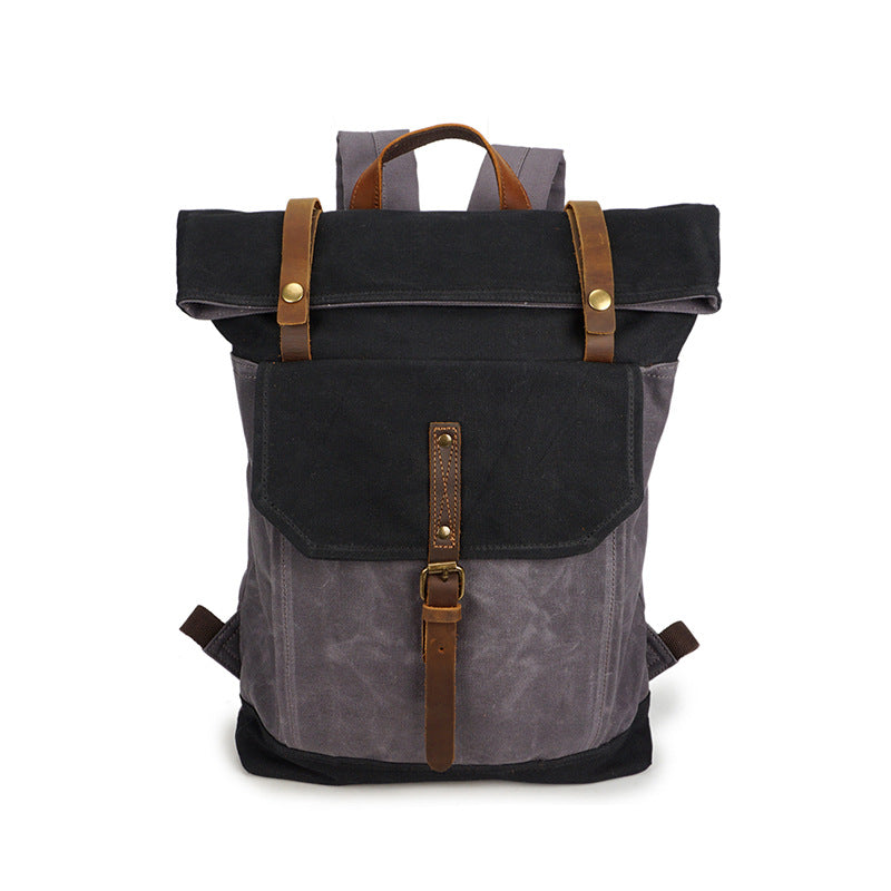 Gray and black canvas roll-top backpack front view with brown straps and buckled front flap