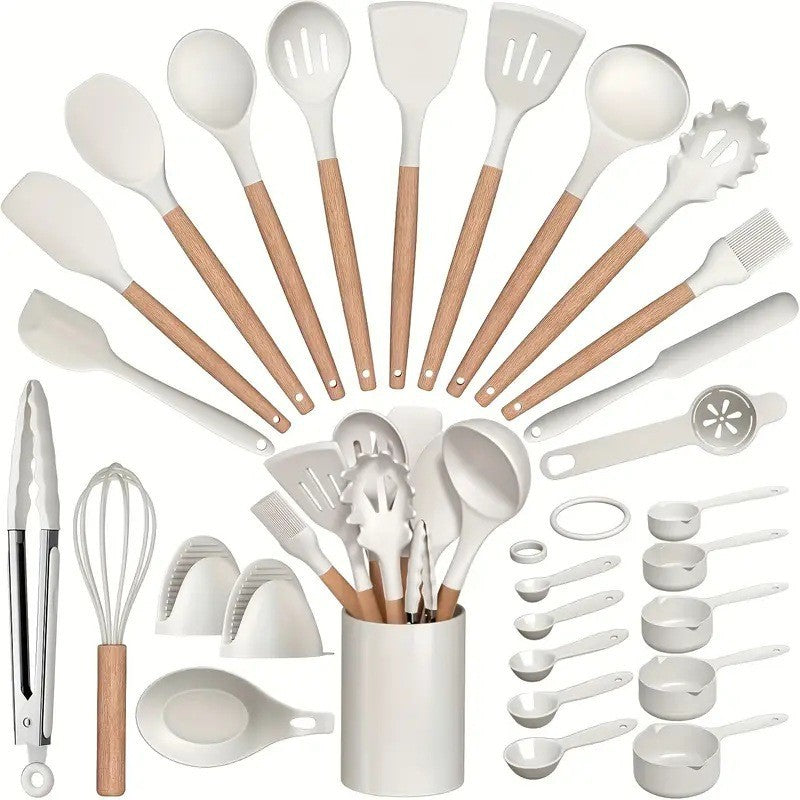 White silicone kitchen utensil set with beech handles arranged in an arc around the matching crock